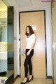 A woman standing in front of a wooden door.