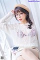 A woman wearing glasses and a beret sitting on a window sill.