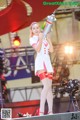 A woman in a white and red outfit holding a rocket.