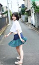 A young woman in a school uniform is walking down the street.