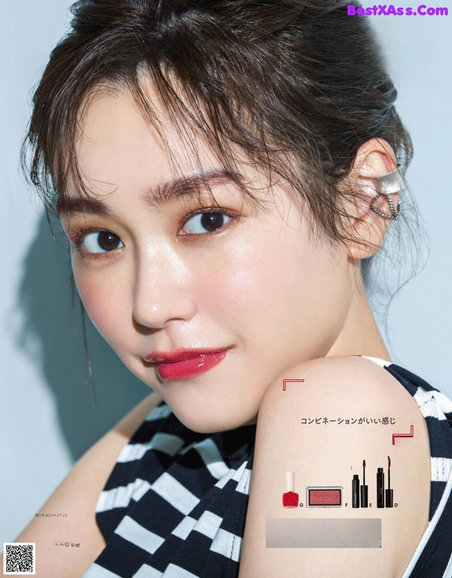 A woman in a black and white striped dress posing for a magazine.